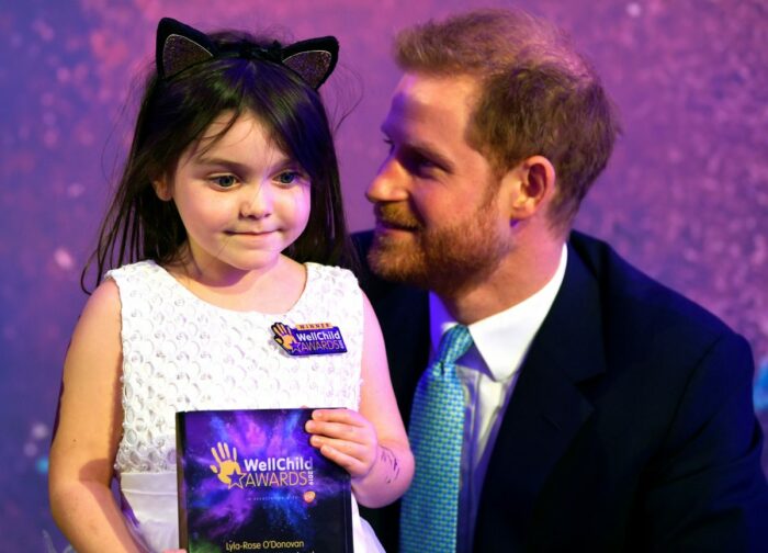 Prince Harry with a child at the Wellchild awards 2019