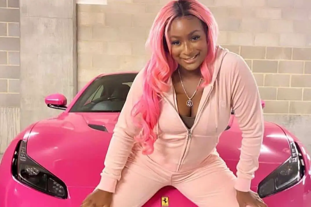 DJ Cuppy posing with her pink Lamborghini