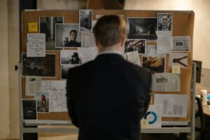 Back View of a private investigator Looking at the Bulletin Board