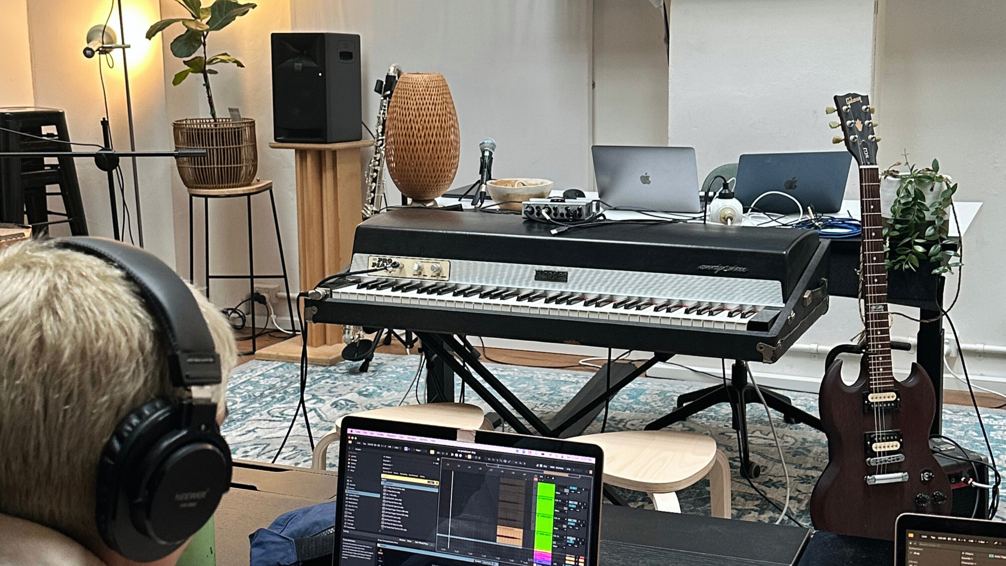 Electronic music producer working in a home studio with synthesizers and Ableton Live