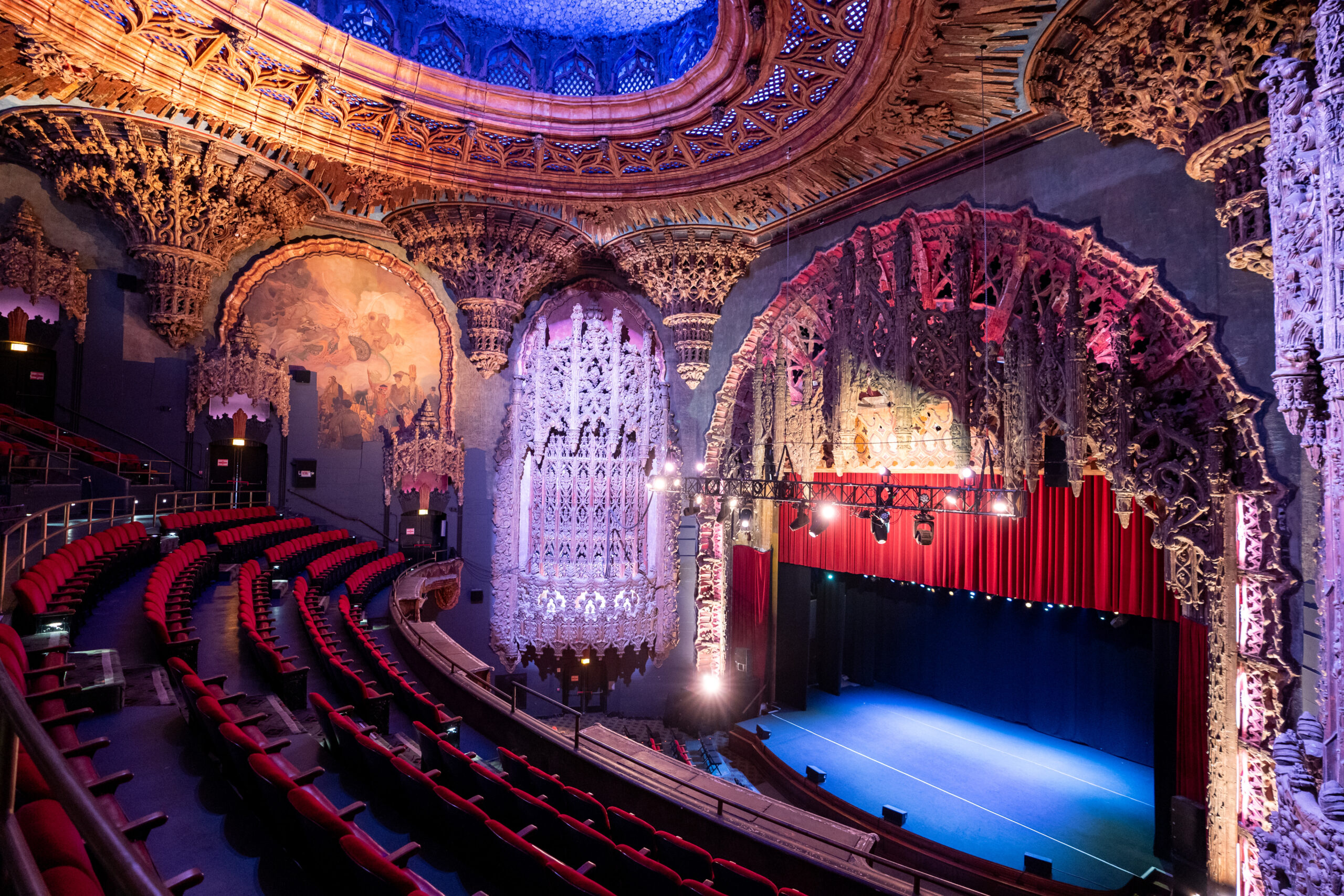 Ornate Broadway theater interior with packed audience and dramatic stage lighting