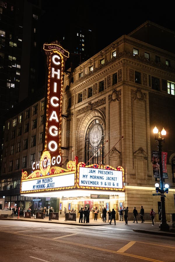 Broadway theater marquee illuminated at night with crowds gathering for evening performance