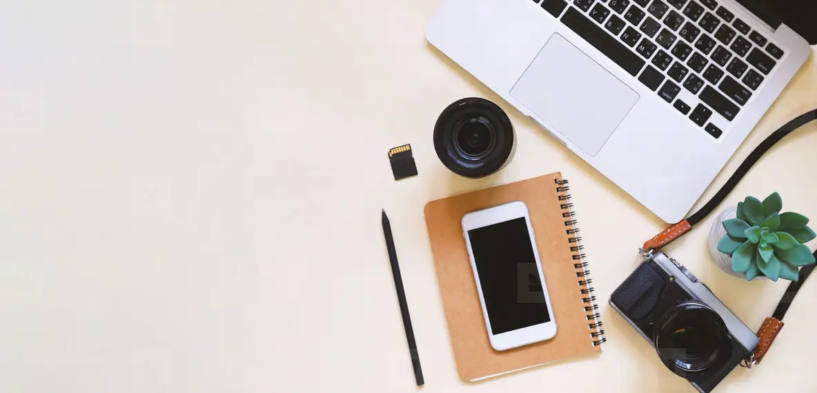 Content creator workspace flat lay with laptop analytics, camera, phone, and brand contracts