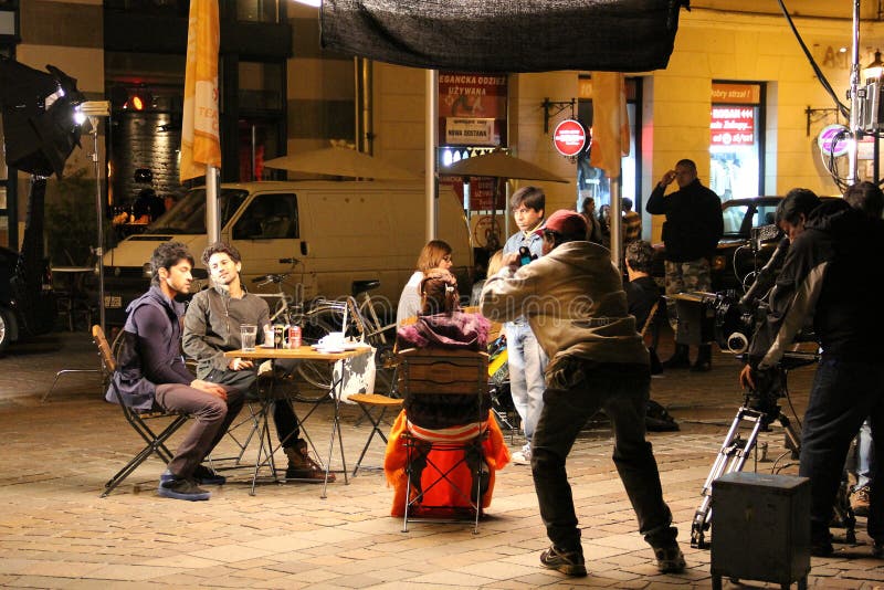 Independent film production shooting on a city street at night with camera dolly and small crew