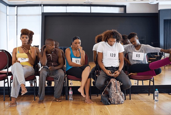 Diverse actors in a casting waiting room preparing for auditions