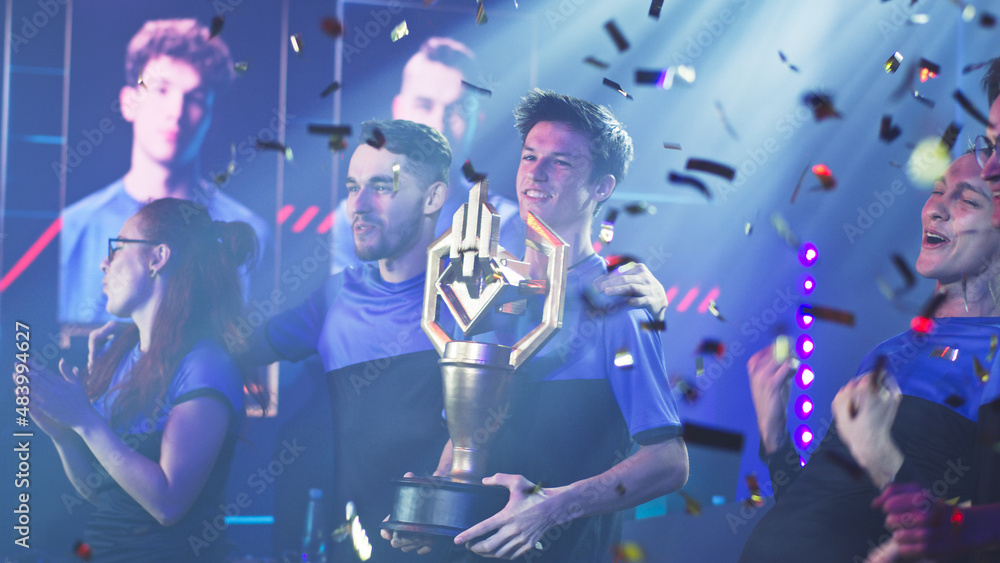 Professional gamer celebrating tournament victory with trophy and confetti