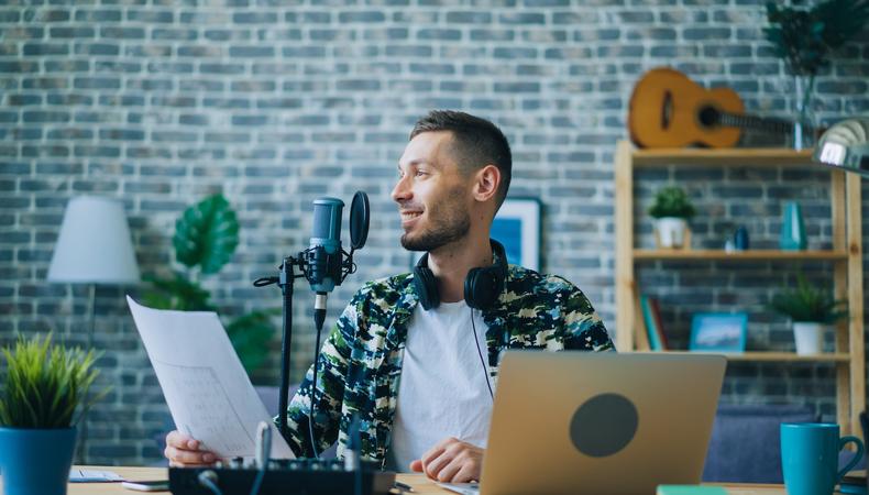 Voice actor browsing voiceover job listings on a laptop at their home office desk