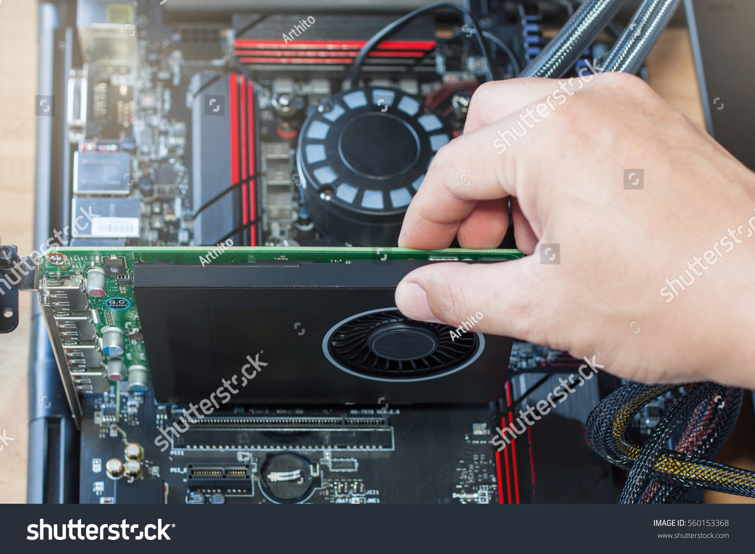 Hands installing a graphics card into a PC motherboard