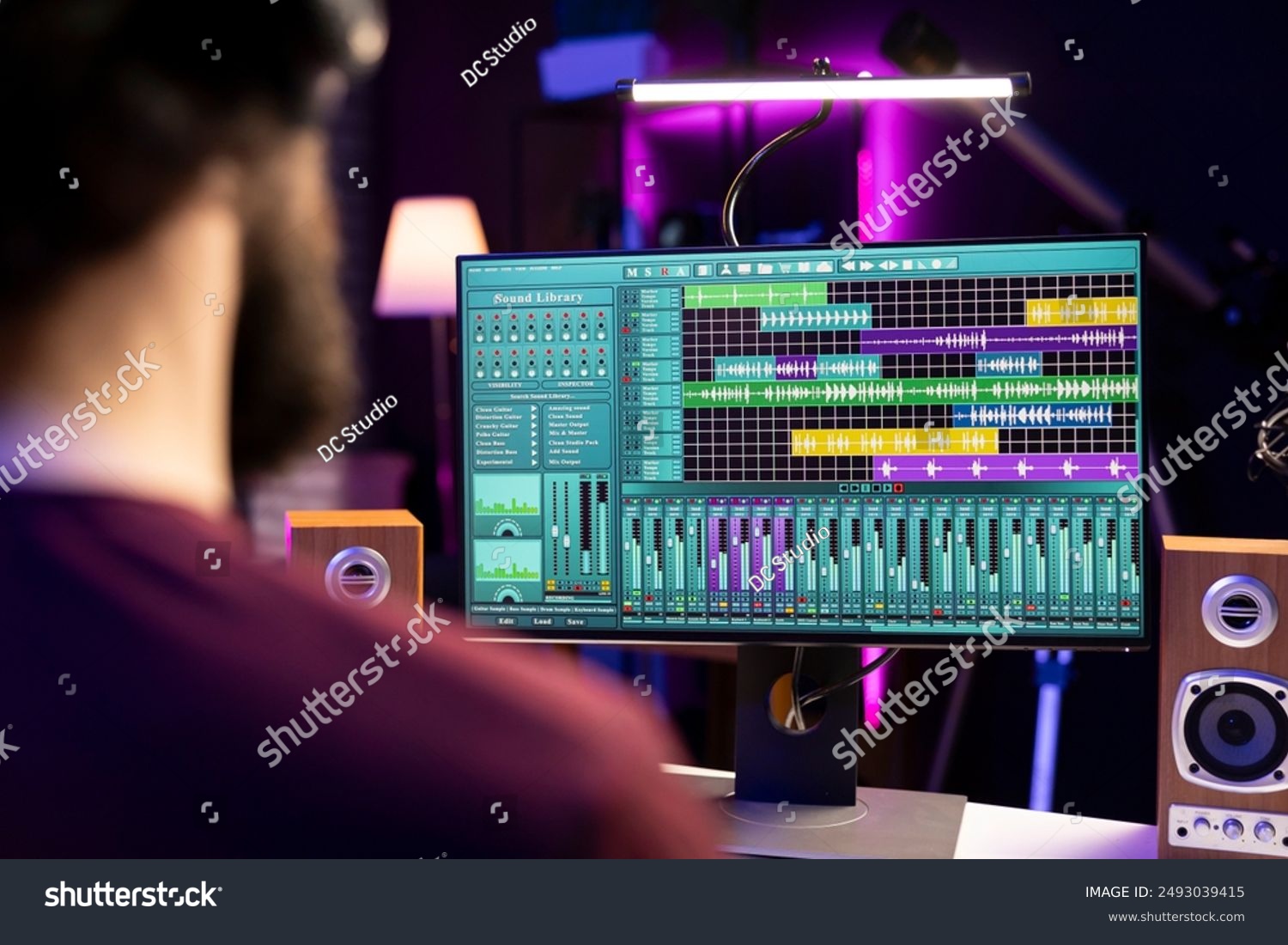 Person wearing headphones while editing podcast audio waveforms on a computer screen