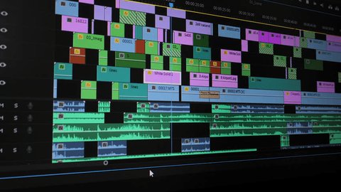 Close-up of a video editing timeline showing cut points between clips with audio waveforms