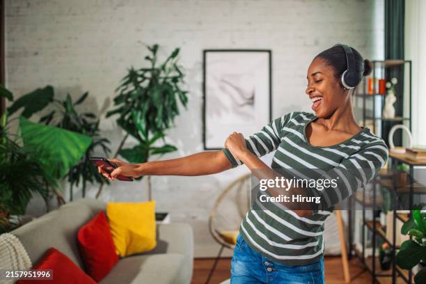 Person dancing freely at home with headphones, enjoying the moment
